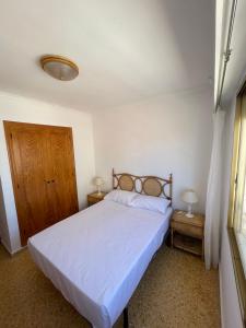 - une chambre avec un grand lit et des draps blancs dans l'établissement Apartamento en segunda linea en playa de Gandia, à Playa de Gandia