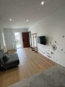 ein Wohnzimmer mit einem Sofa und einem TV an der Wand in der Unterkunft Appartement T2 à centre ville in Brive-la-Gaillarde