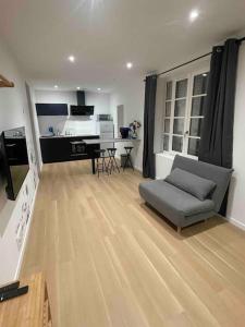 ein großes Wohnzimmer mit einem Sofa und einer Küche in der Unterkunft Appartement T2 à centre ville in Brive-la-Gaillarde
