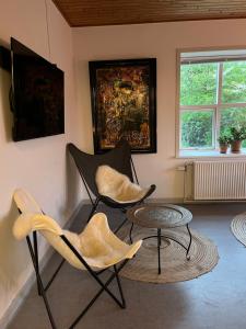 dwa krzesła i stół w pokoju w obiekcie Room 8 - Hawkraft kulturhotel w mieście Vestervig