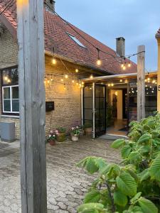 a brick building with a patio with lights on it at Room 8 - Hawkraft kulturhotel in Vestervig