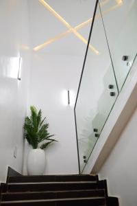 un escalier avec une plante dans un vase blanc dans l'établissement Morak Homes - Luxury 4 bed home with PS5, 24hrs electricity, Super fast Wifi, Snooker, Games room - in a secured estate, à Abuja