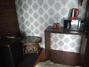 a corner of a room with a table and a microwave at Fazenda Morro Das Torres in Urupema