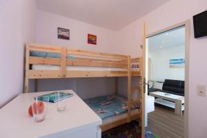ノイシュタット・イン・ホルシュタインにあるPrinz-Hamlet-App-16の二段ベッド1組、キッチンが備わる小さな客室です。