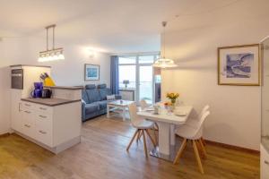 a kitchen and a living room with a table and chairs at Prinz-Hamlet-App-133-in-Pelzerhaken in Neustadt in Holstein