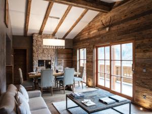 a living room with wooden walls and a table with a couch at Chalet-Apartment Holunder am Lift in Kirchberg in Tirol