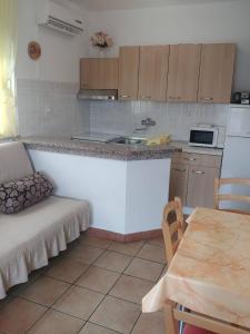 a kitchen with a counter and a table with a chair at Apartment Kornic 5306b in Kornić