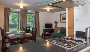 a kitchen and living room with a stove and a table at Raven Wing Apartments - Highland Club Scotland in Fort Augustus