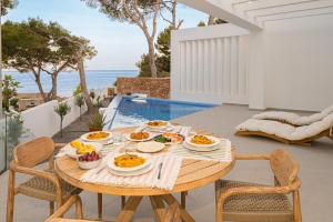 uma mesa com pratos de comida ao lado de uma piscina em BALILOS 4 - By Almarina Villas em Benissa