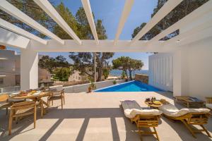 un patio con tavolo, sedie e piscina di BALILOS 4 - By Almarina Villas a Benissa