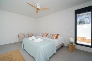 ベニッサにあるBALILOS 4 - By Almarina Villasのベッドルーム1室(ベッド1台、テーブル、シーリングファン付)
