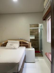 a bedroom with a bed and a walk in shower at Hotel Carrão in Sao Paulo