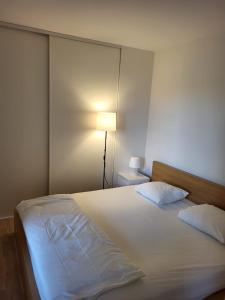 1 dormitorio con 1 cama blanca grande con lámpara en JECI Apartment Frogner, Lillestrøm - Classic and Central, en Lillestrøm