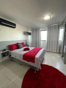 a bedroom with a large bed with red pillows at Flat Lindo e Aconchegante in Recife