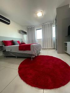 a bedroom with a large red rug on the floor at Flat Lindo e Aconchegante in Recife