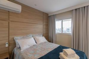 um quarto com uma cama com uma cabeceira em madeira e uma janela em Lovely Studio - GRU em Guarulhos