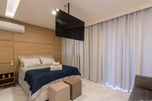 um quarto com uma cama e uma televisão de ecrã plano em Lovely Studio - GRU em Guarulhos