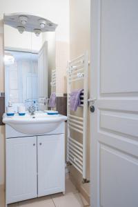 La salle de bains blanche est pourvue d'un lavabo et d'un miroir. dans l'établissement Mille Sabords 4 pers à 20 minutes de Beauval, à Montrichard