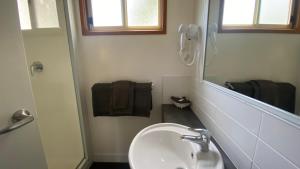 a white bathroom with a sink and a mirror at Twin Dolphins Holiday Park in Tuncurry