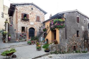 stary kamienny budynek z kwiatami na dziedzińcu w obiekcie Dimora Turistica de' Piazza w mieście Roccalvecce