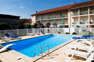 een zwembad met ligstoelen en een hotel bij Hostellerie de La Poste in Oust