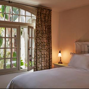 um quarto com uma cama e uma grande janela em Chateau Marmont em Los Angeles