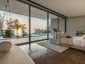 a bedroom with a bed and large glass windows at Veyla Natai Residences - Luxury Pool Villa in Khok Kloi +75 photos