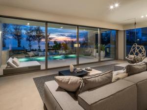 a living room with a couch and a large window at Veyla Natai Residences by Elite Havens in Ban Na Phong