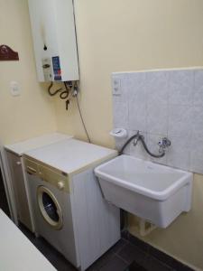 a bathroom with a washing machine and a sink at Comodo Departamento in San Juan