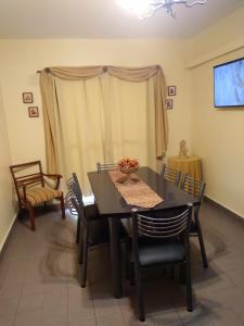 a dining room with a black table and chairs at Comodo Departamento in San Juan