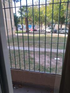 una ventana con vistas a un parque a través de una valla en Comodo Departamento en San Juan