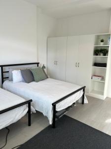 a bedroom with two beds and white cabinets at Hackney Apartment in London