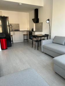 a living room with a couch and a kitchen at Hackney Apartment in London