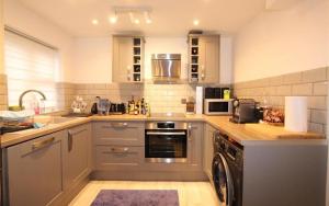 a kitchen with a sink and a dishwasher at Modern newly decorated 25 Min from City of London in London