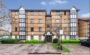 un immeuble d'appartements avec un parking en face de celui-ci dans l'établissement Modern newly decorated 25 Min from City of London, à Londres