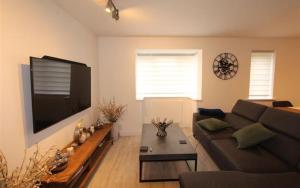 a living room with a couch and a flat screen tv at Modern newly decorated 25 Min from City of London in London