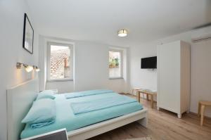 a white bedroom with a bed and a table at Apartments and rooms with WiFi Rovinj - 20857 in Rovinj +12 photos