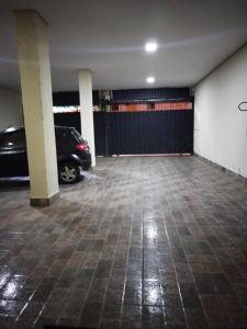 a garage with a car parked next to a black fence at Seabra serviços de hotelaria limitada in Brasilia