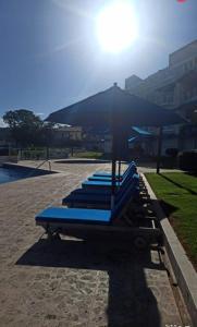 una fila di panchine blu sedute in un parco di Penthouse de lujo con increíble vista al mar a Sosúa