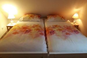 a bedroom with two beds with flowers on them at Family friendly house with a swimming pool Gospic, Velebit - 21171 in Gospić +12 photos