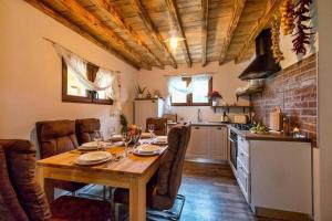 eine Küche und ein Esszimmer mit einem Holztisch und Stühlen in der Unterkunft Family friendly house with a swimming pool Gospic, Velebit - 21171 in Gospić