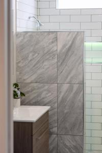 y baño con ducha y lavamanos. en St Albans Gem Single level studio with Queen bed en Christchurch