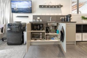 cocina con fregadero y microondas en St Albans Gem Single level studio with Queen bed en Christchurch