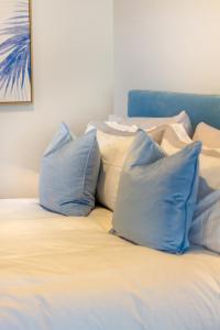 een bed met blauwe en witte kussens erop bij St Albans Gem Single level studio with Queen bed in Christchurch