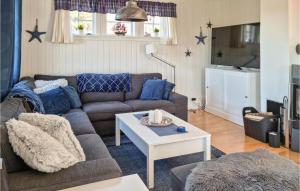 ein Wohnzimmer mit einem Sofa und einem Tisch in der Unterkunft Amazing Home In Risr With Wifi in Risør