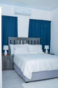 una camera da letto con un grande letto con tende blu di Rio Lodge a Butterworth