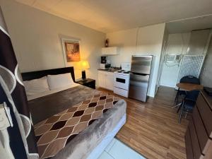 a small bedroom with a bed and a kitchen at West Castle Motel in Pincher Creek