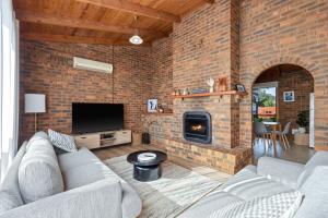 a living room with two couches and a brick wall at Redwood Beach House - with 10 percent off until September in Cowes