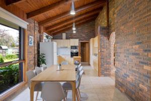 a dining room with a table and a brick wall at Redwood Beach House in Cowes