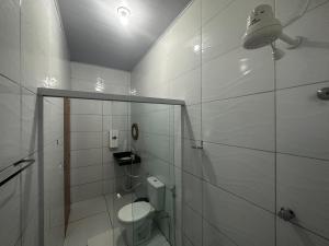 a white bathroom with a toilet and a shower at POUSADA E AGENCIA CLEDIO TURISMO in Barreirinhas